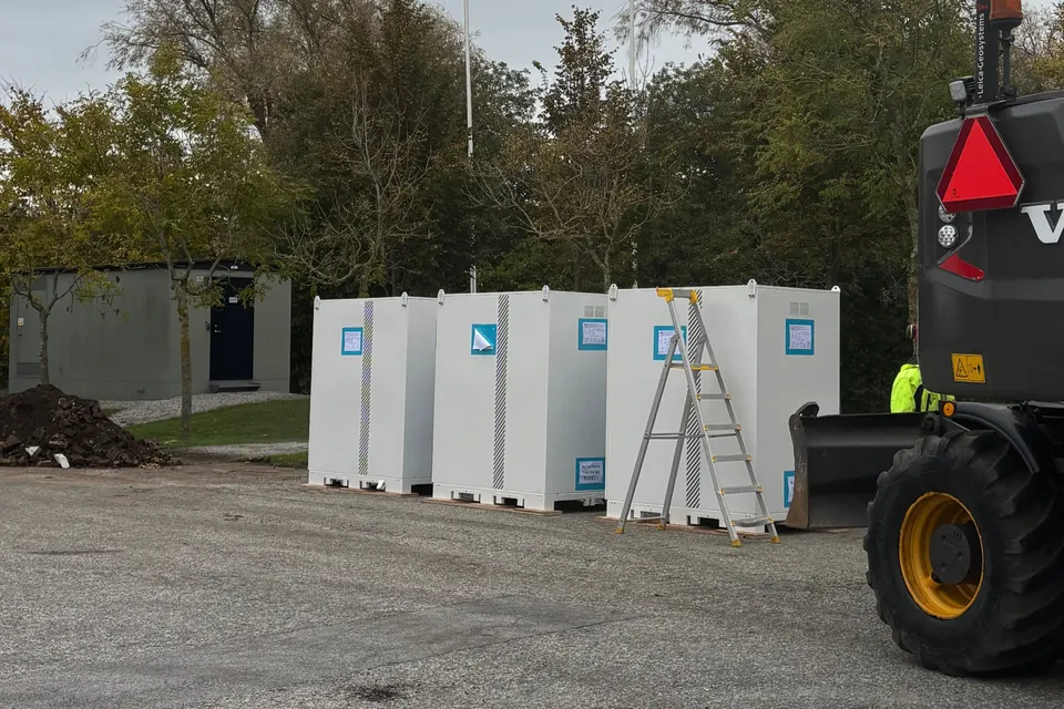 Batteriskåp placerade utomhus på fundament, en bit från en byggnads fasad